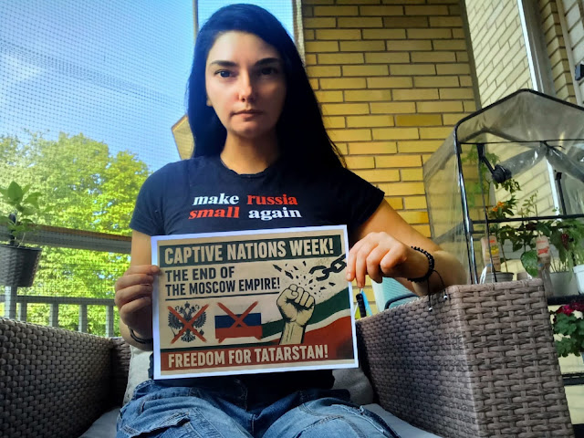 An activist holds a sign during Captive Nations Week.
