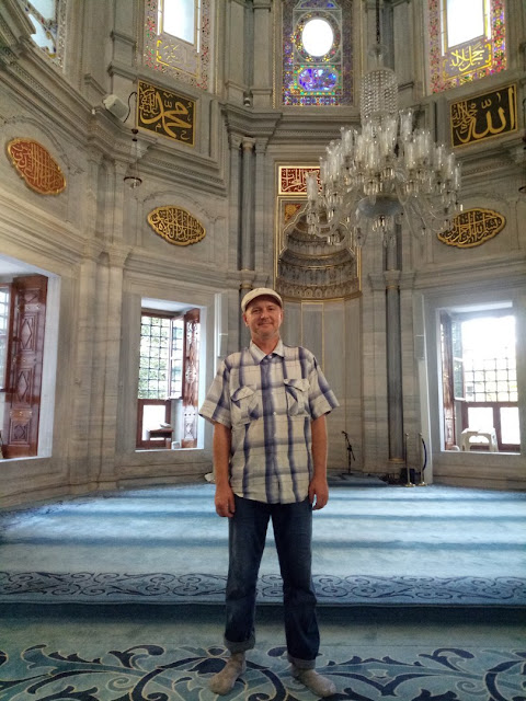 A man stands inside an ornate public interior.