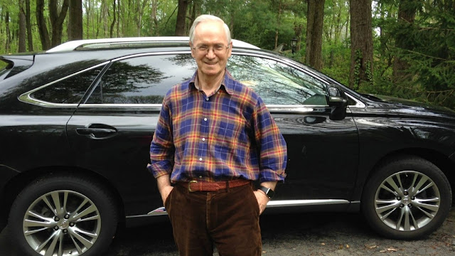 Vil Mirzayanov stands outdoors beside a car.